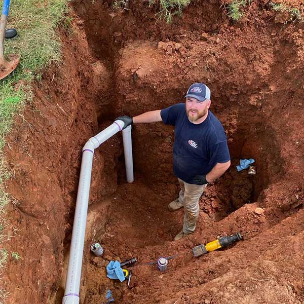 luke kelley fixing a sewer pipe